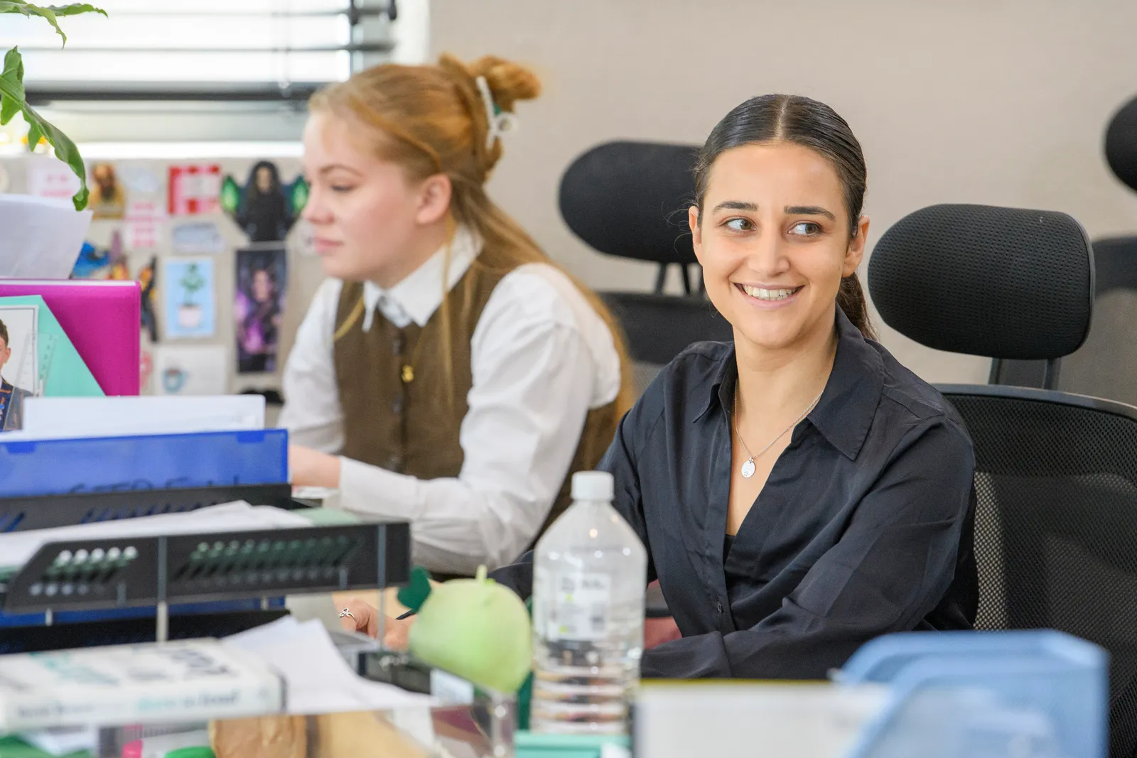 A Genius team member smiling while working at her desk