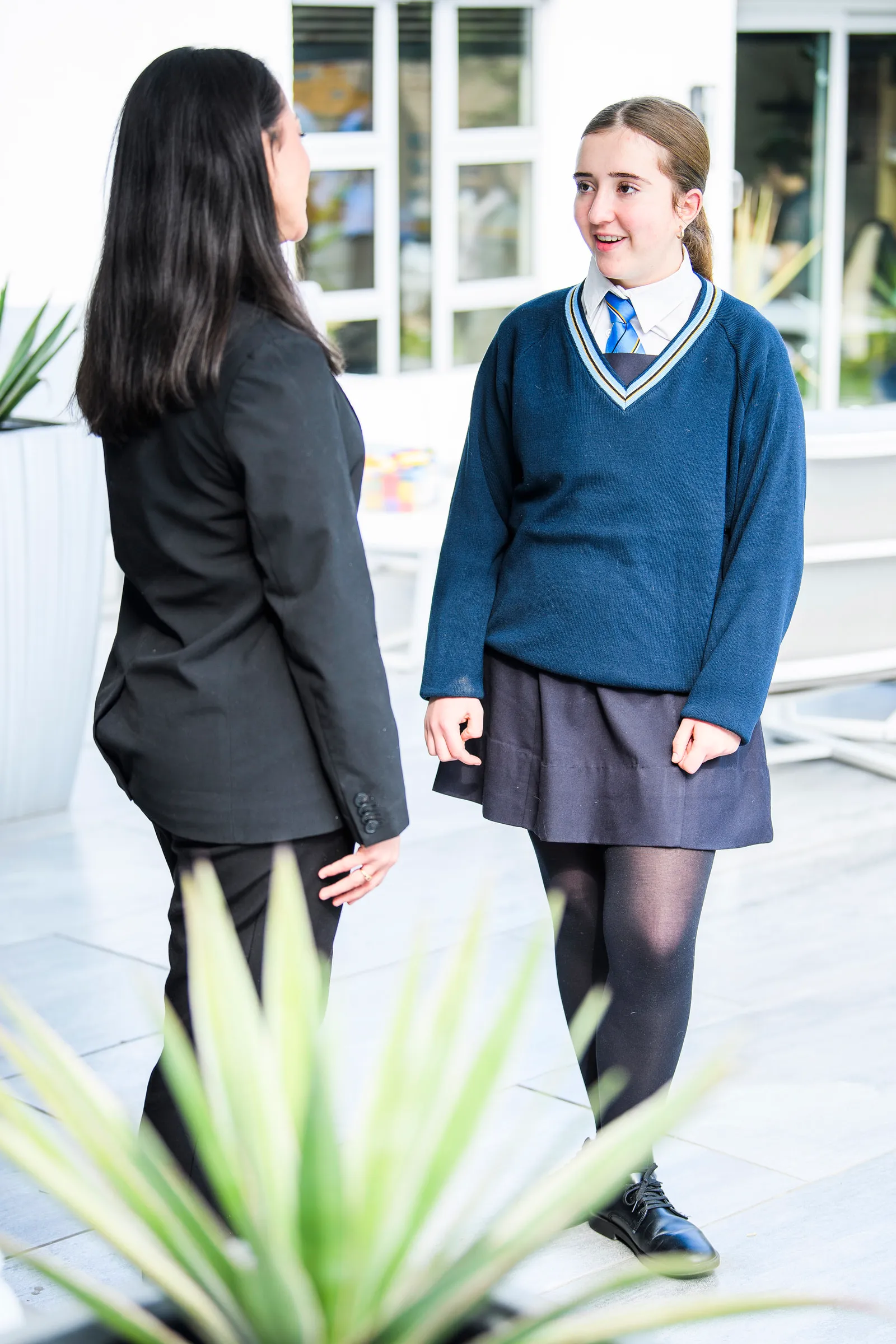 A school student speaking with an Education Leader on a bright patio