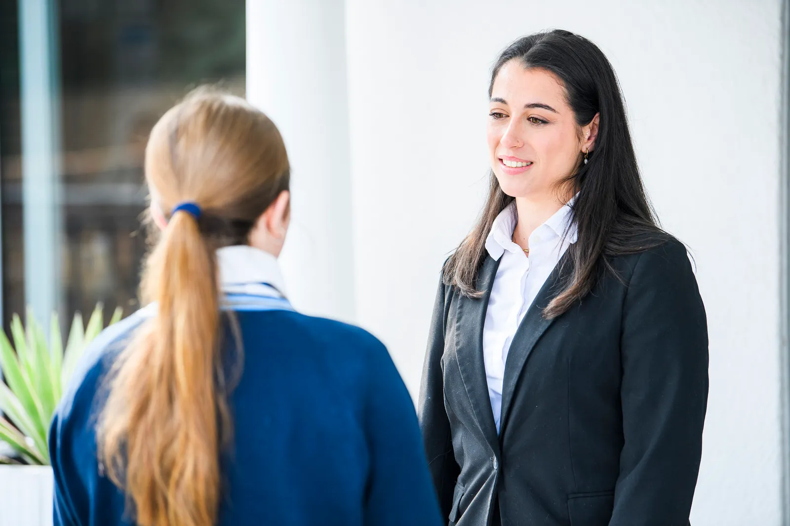 An Education Leader smiling warmly during a student consultation