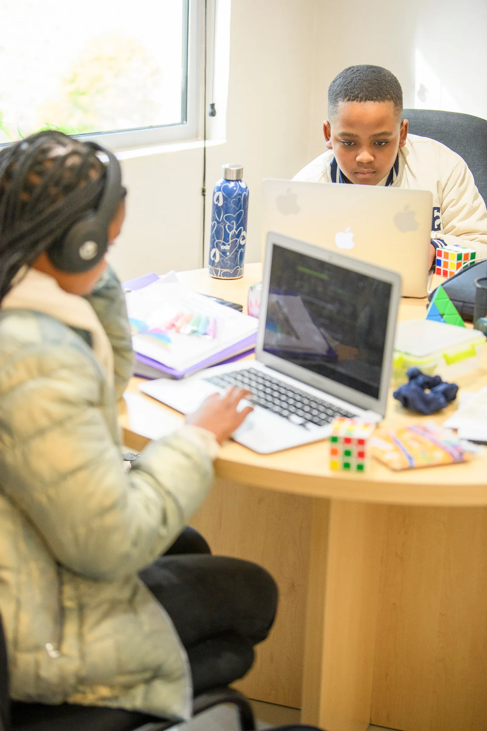 A student concentrating on his laptop in a shared study space