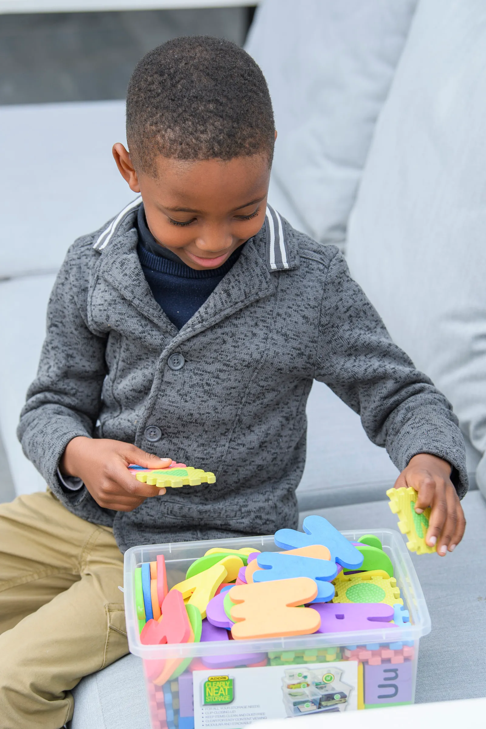 A young learner actively working with colourful alphabet pieces