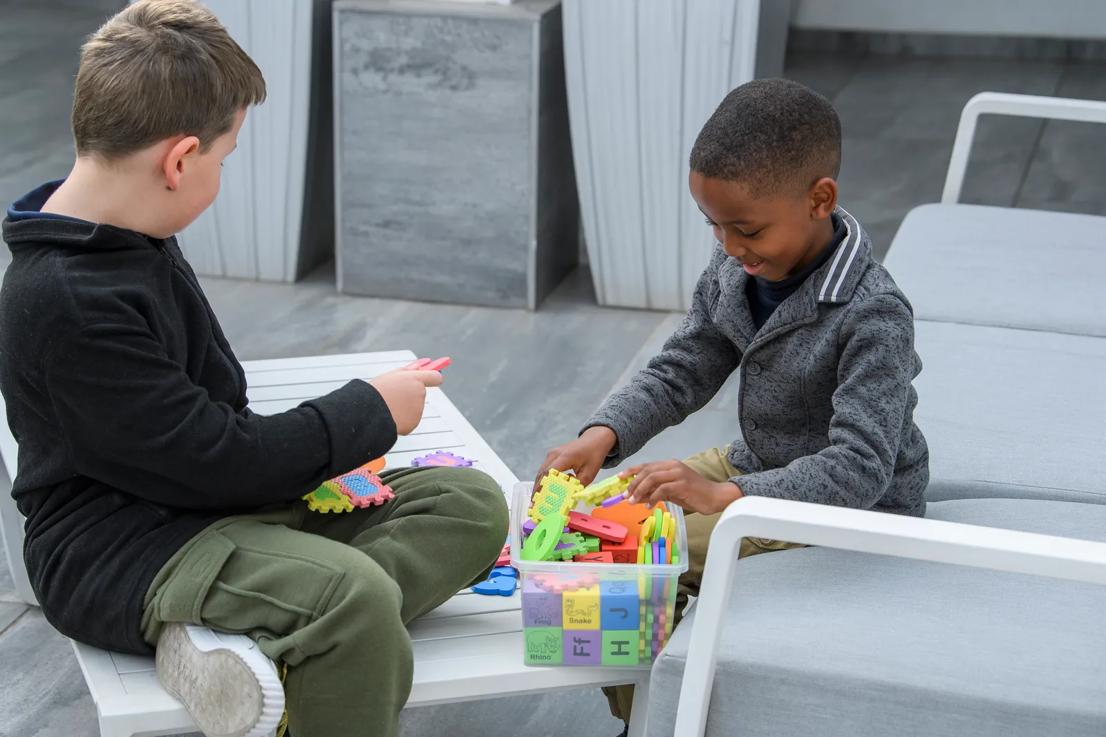 Two young learners working together with colourful letter blocks