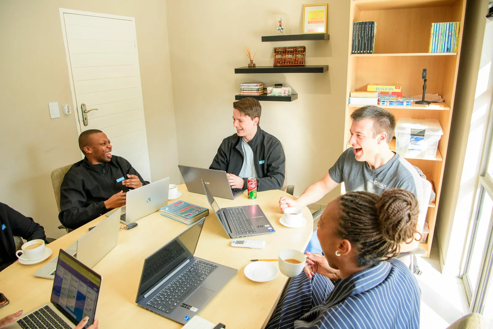 A Genius team meeting in a bright room with learning materials