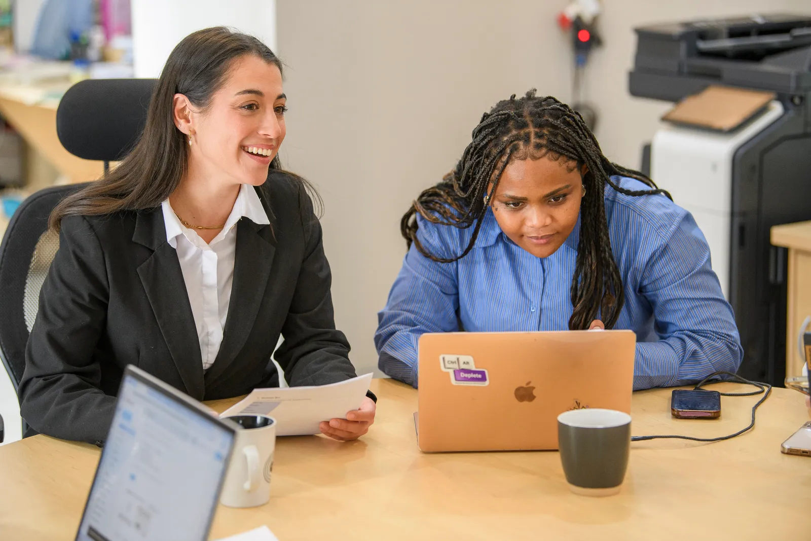 Genius colleagues reviewing written work together at a shared desk