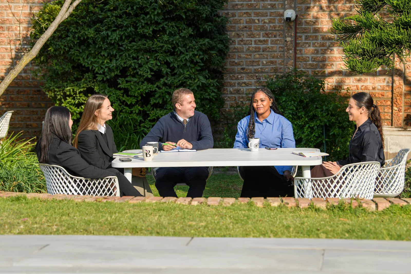 The Genius team collaborating around an outdoor working table