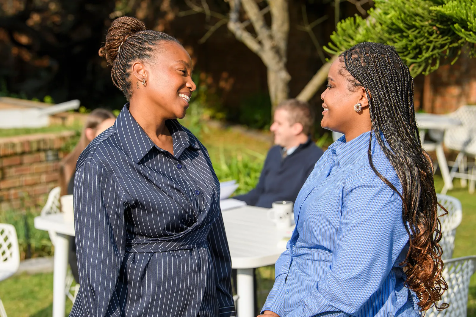 Two Genius colleagues sharing a warm conversation outdoors