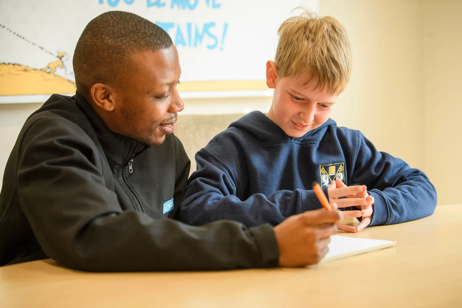 A Genius tutor encouraging a young learner as he works through a problem