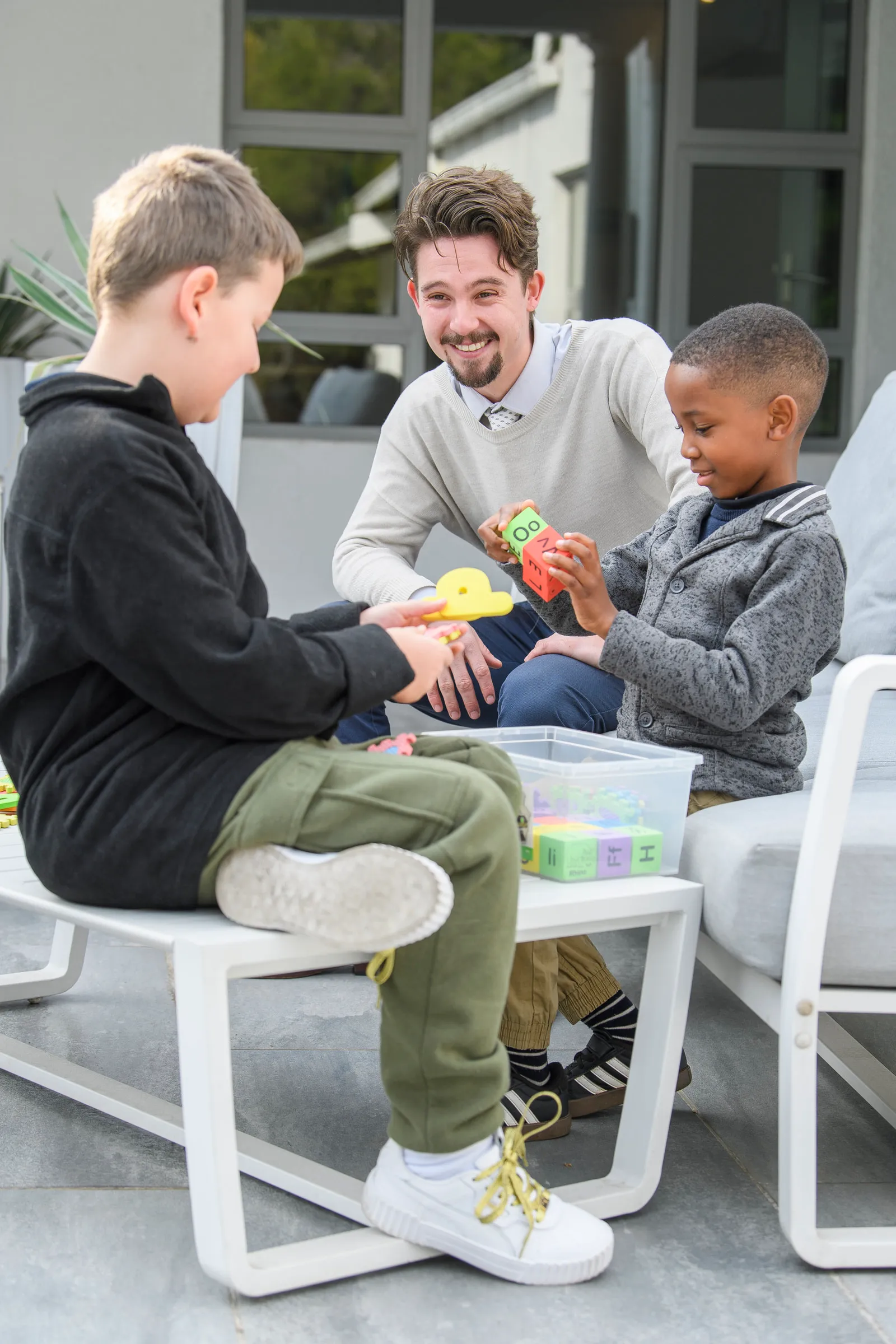 A tutor and two young learners working together with learning blocks